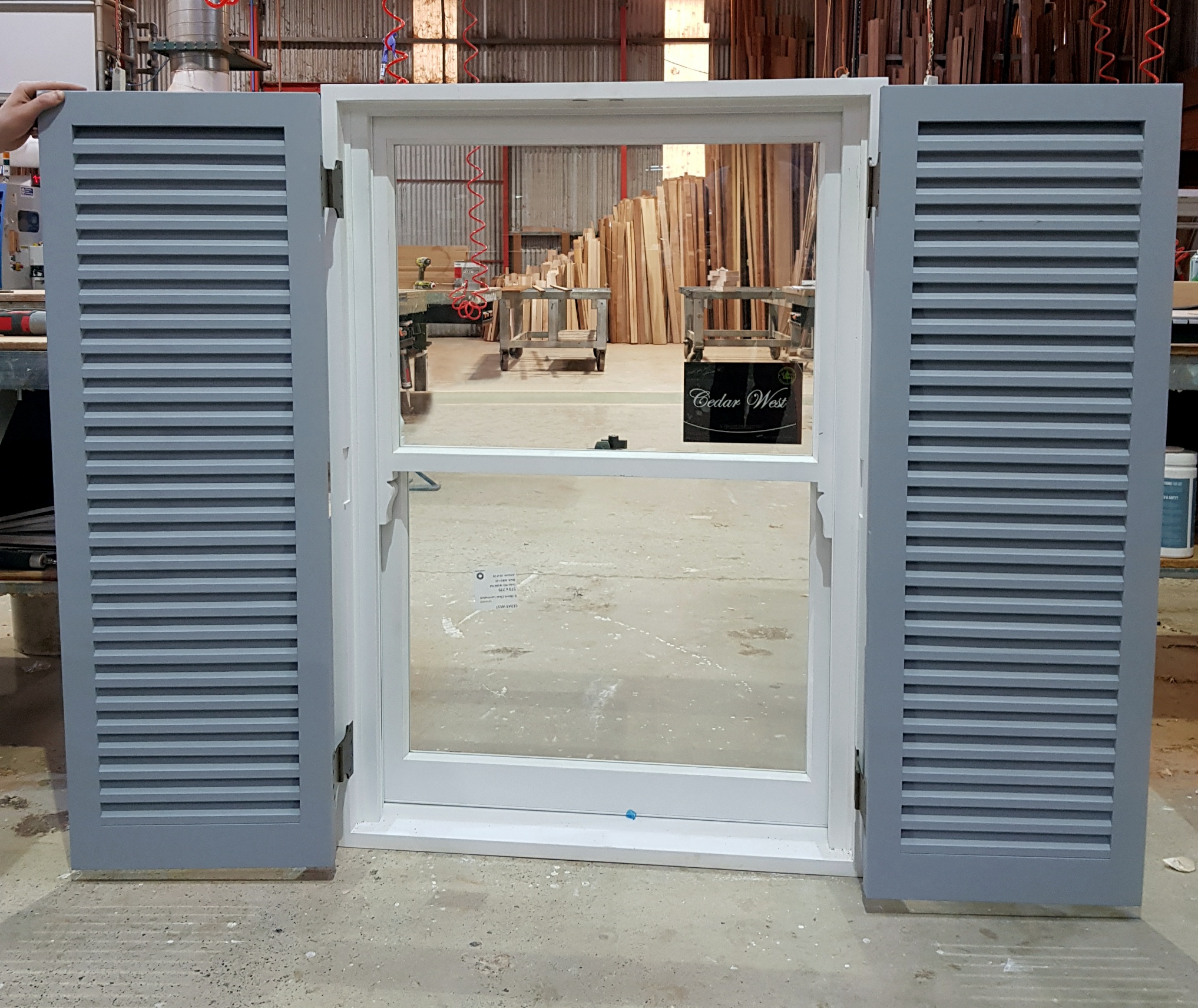 Double-hung window prefitted into frame with external timber shutters fitted