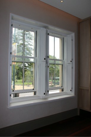 Double hung window painted white timber heritage shutters