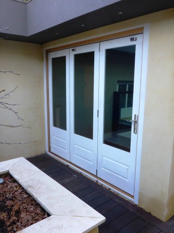 Bifold doors partially glazed painted white timber Cedar West